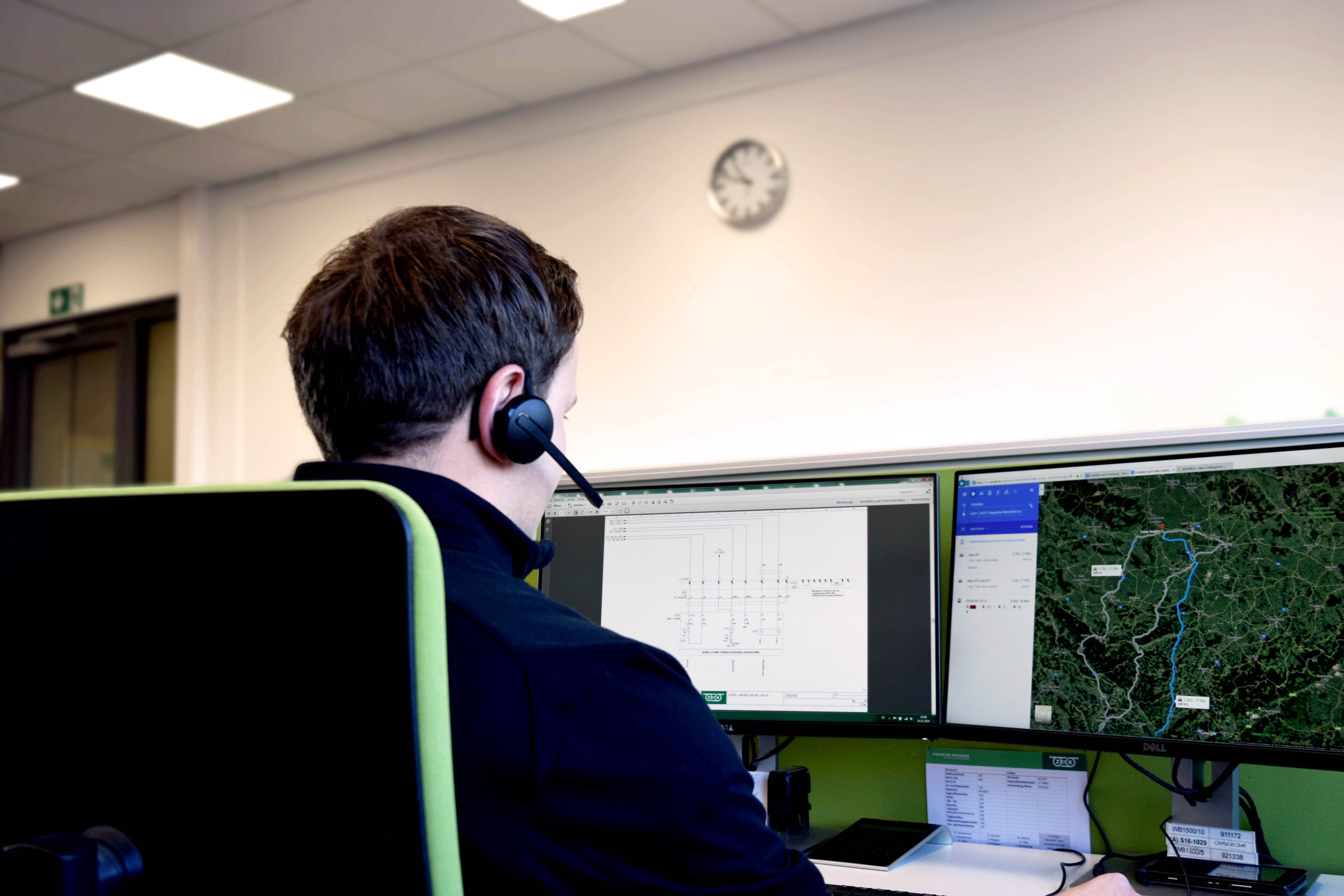 Mitarbeiter des Technischen Supports mit Headset vor zwei Bildschirmen, rechts eine Kartenansicht