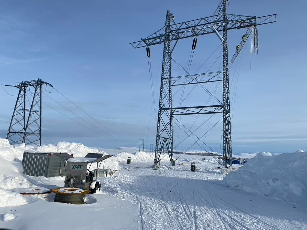 ZECK-Maschine im Schnee an einer Freileitung mit Gittermasten