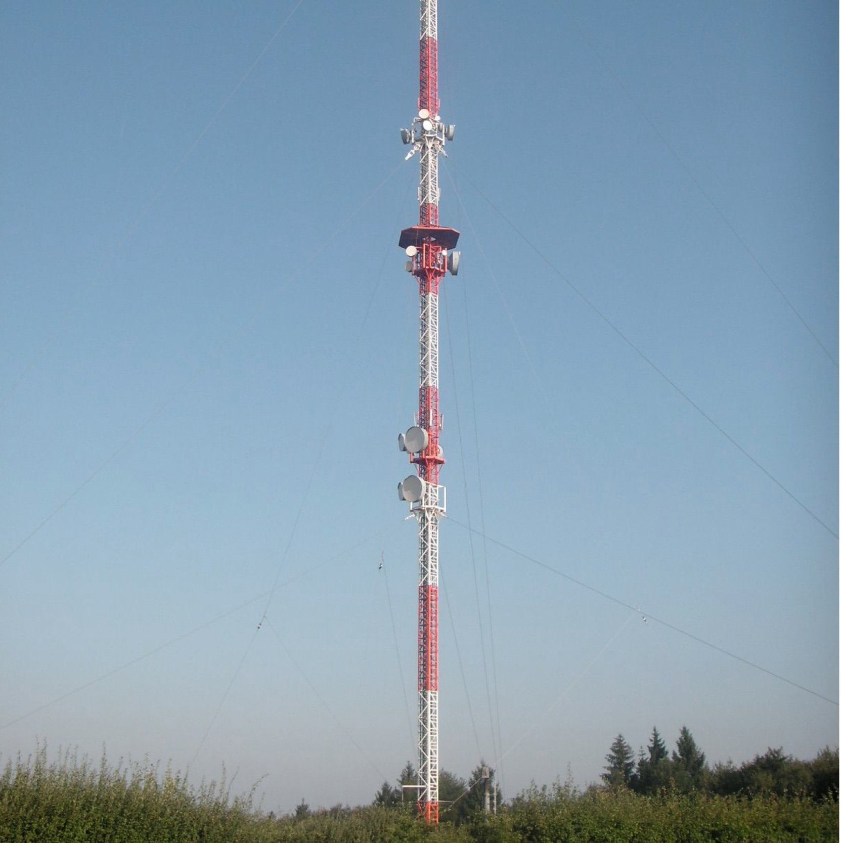 Transmission mast with antennas against a blue sky