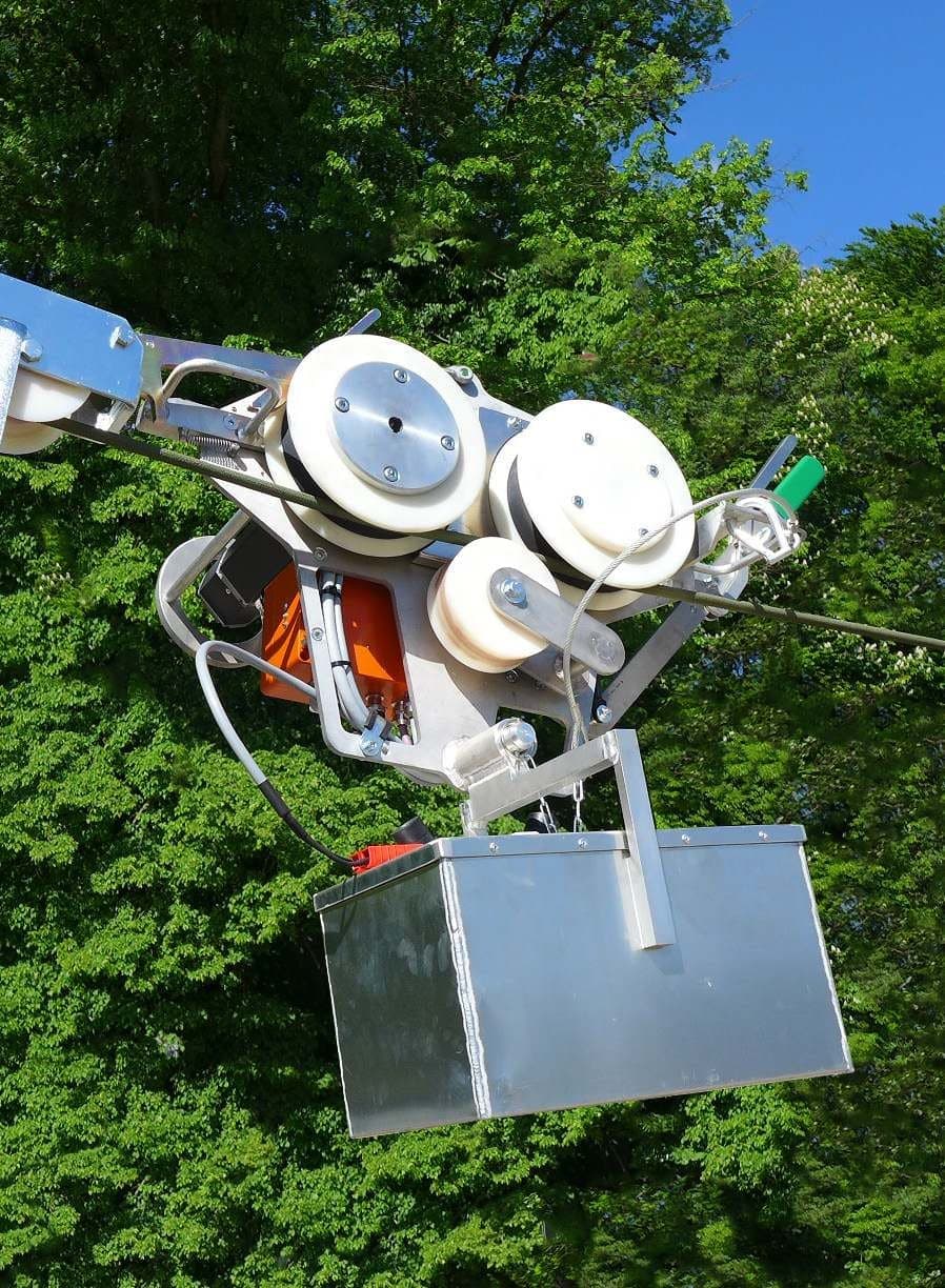 ZECK pulling robot on a conductor in front of green trees
