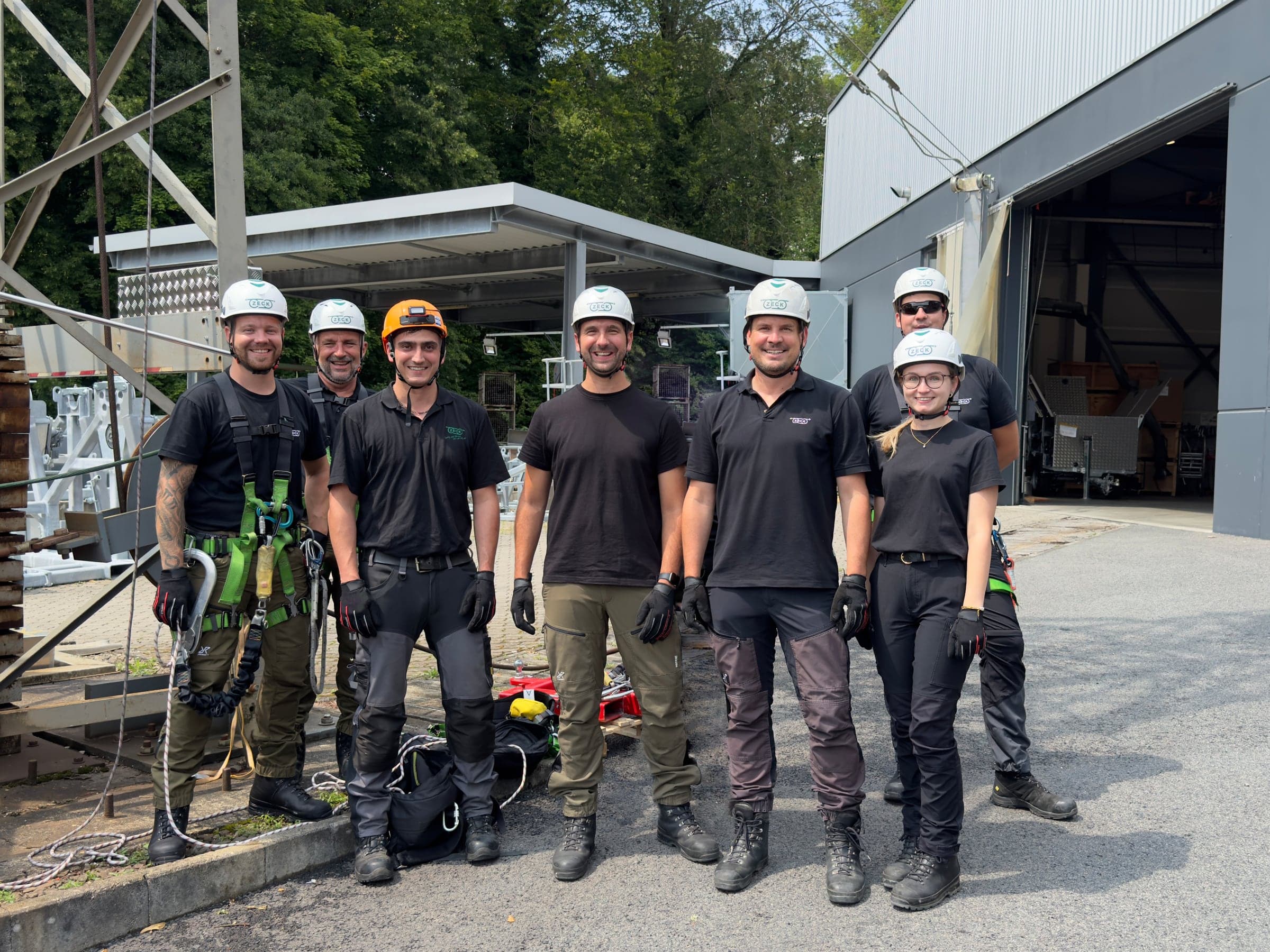 Das Team der ZECK Academy in Schutzausrüstung vor der Schulungshalle