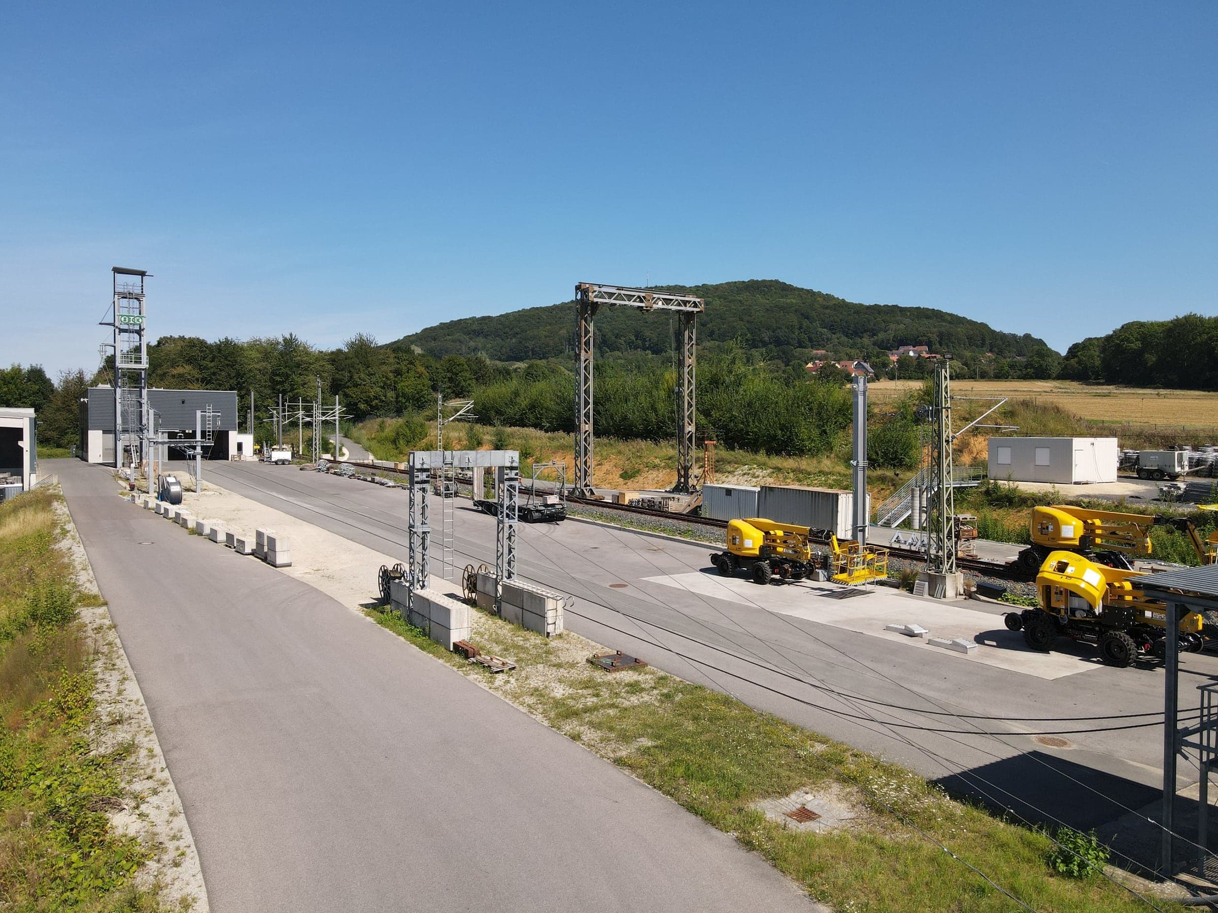 Luftbild des Testgeländes mit Bahnstrecke, Masten und Hubarbeitsbühnen