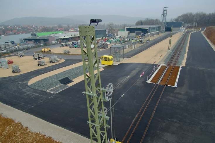 Railway track with overhead contact line mast at the ZECK Academy site